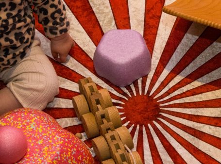 Speelmat met een kleurrijk ontwerp en verschillende speelgoedstukjes zoals blokken.